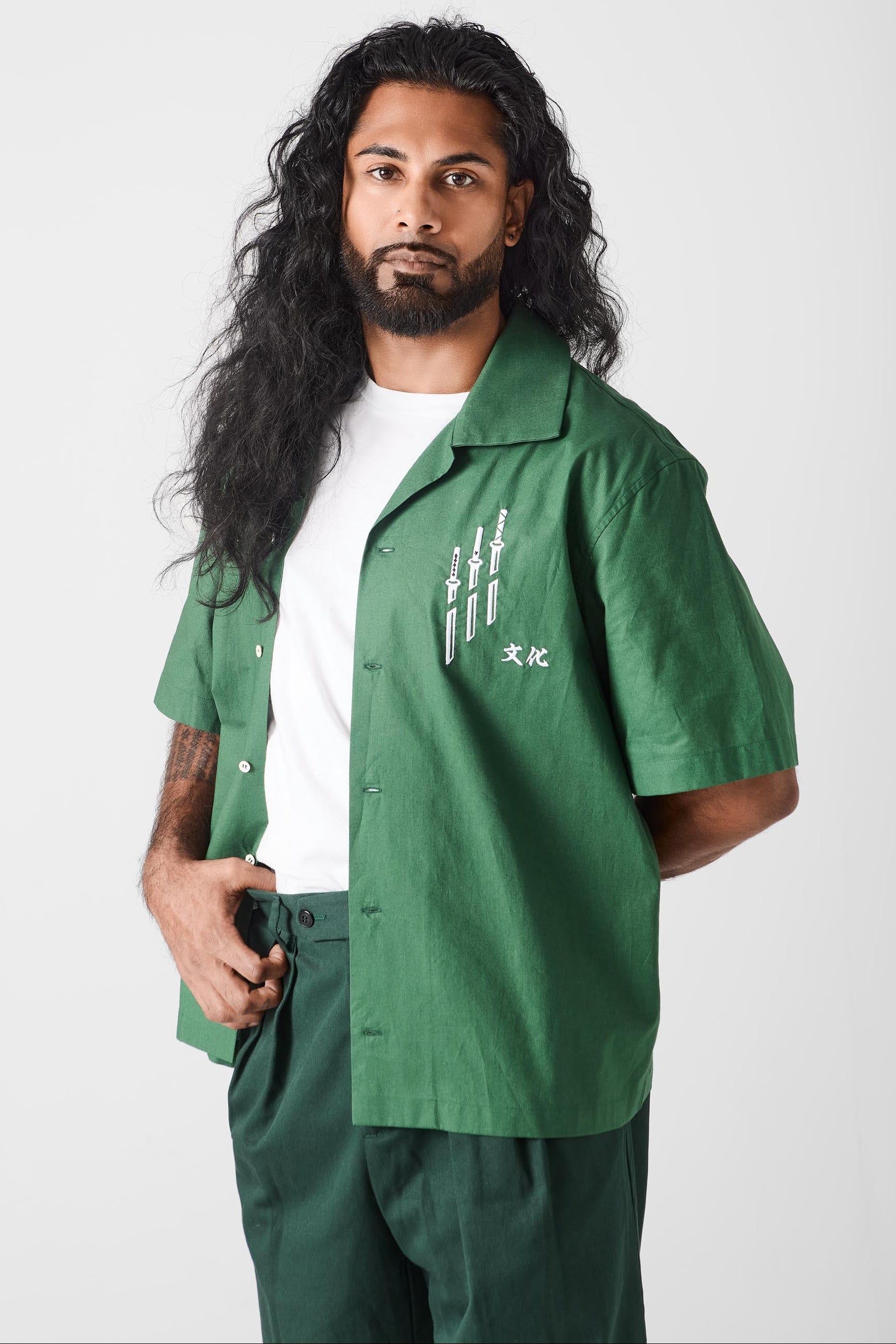 Man wearing a green shirt with white text on a white background